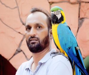 Jehanzaib Ahmed - the founder and CEO of WildlyPet with his pet Macaw sitting on his shoulder